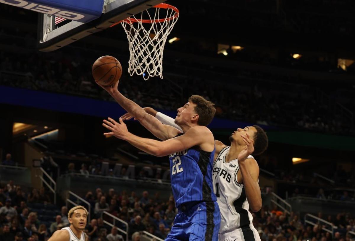 Orlando, FL; Franz Wagner (22) takes the ball to the hoop while Victor Wembanyama (1) goes for a block. 2/8/24.